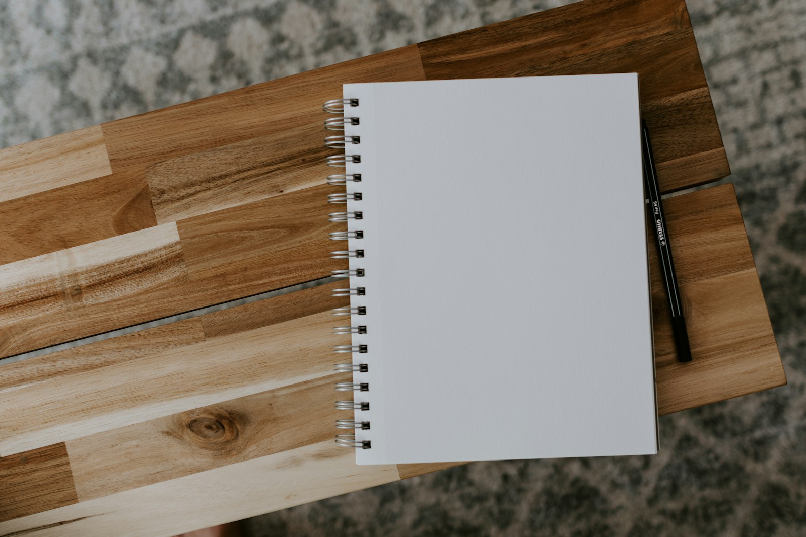 Open notebook and pen on a wooden desk